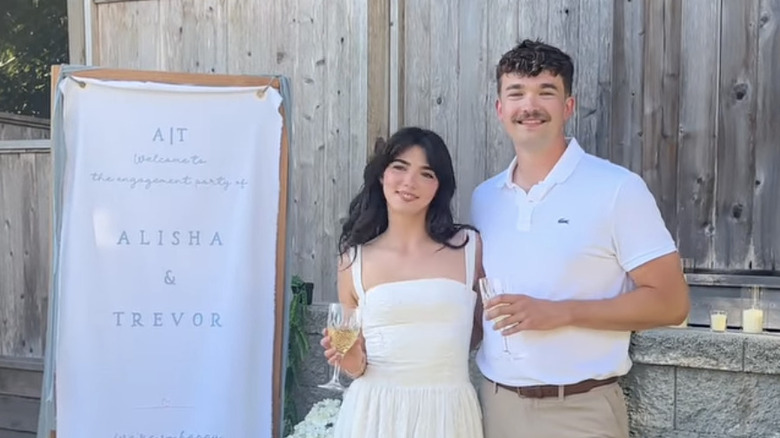 Alisha Newton and Trevor pose with their arms around one another during their engagement party