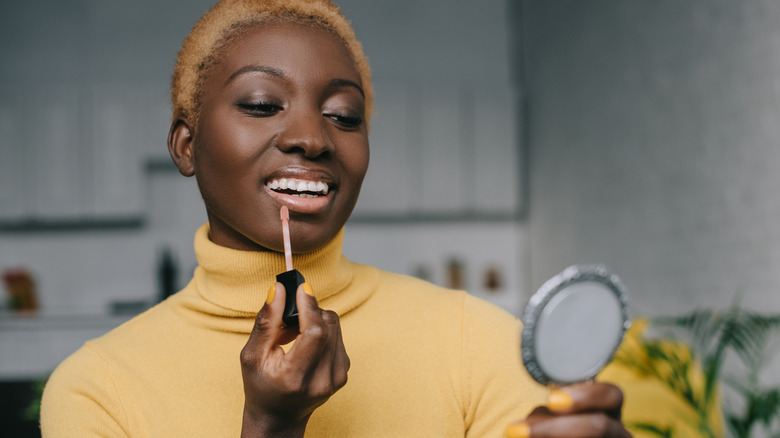 Woman applying lip gloss