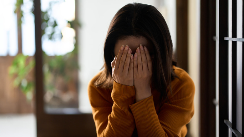 woman crying into her hands