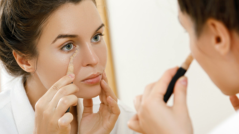 Woman applying under-eye concealer