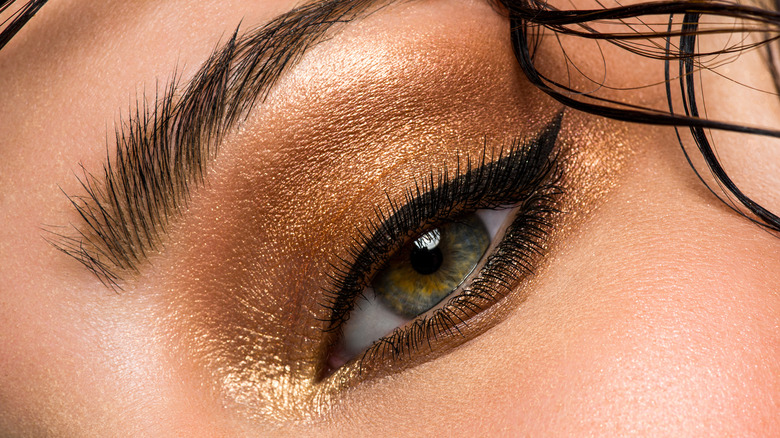 female eye with shiny makeup.