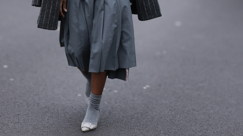 Person in flats, midi skirt