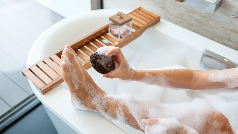 bathing woman using pumice stone