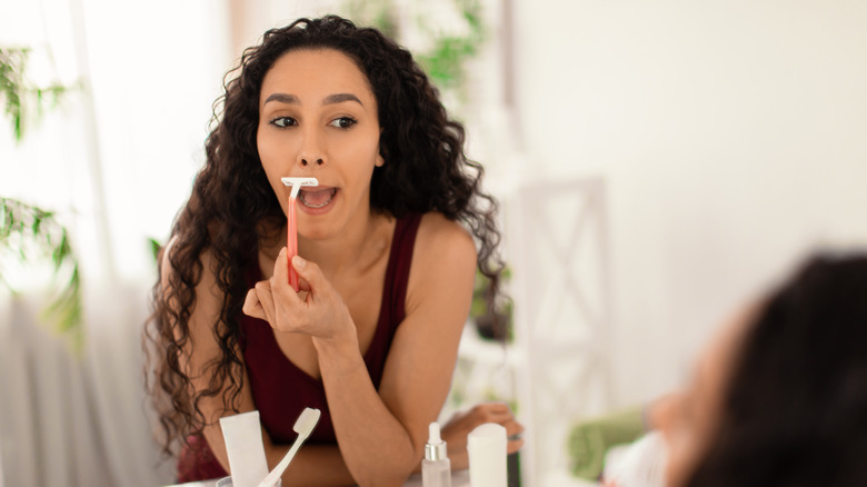 Woman shaving her face