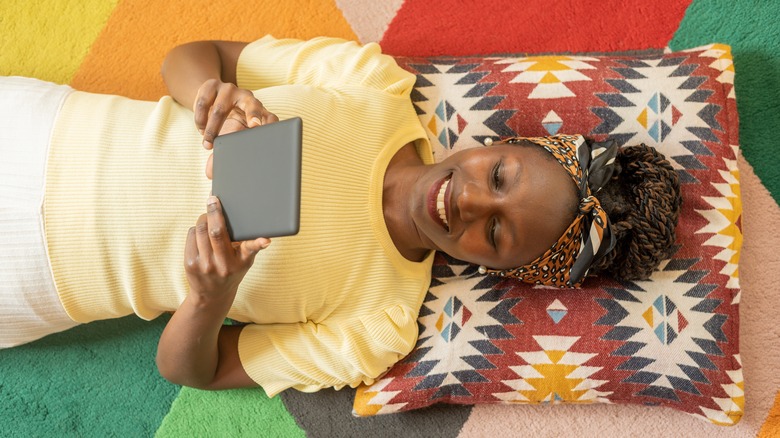 Woman laying on floor with Kindle