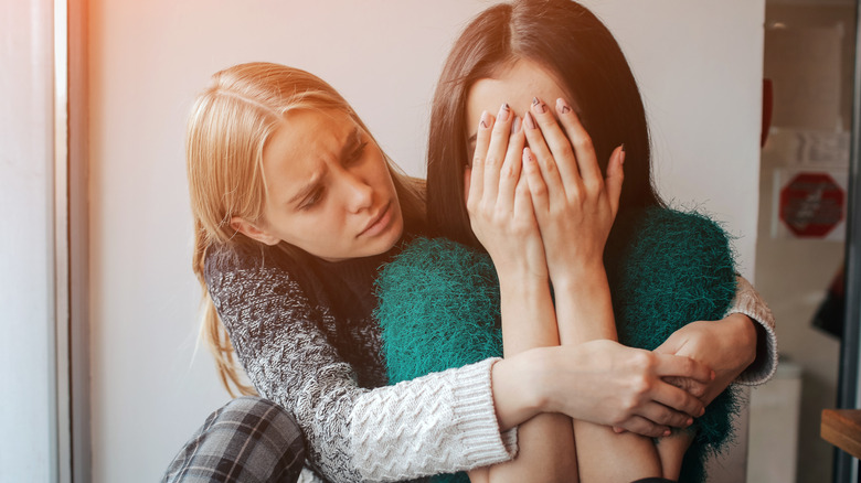 woman hugging unhappy friend