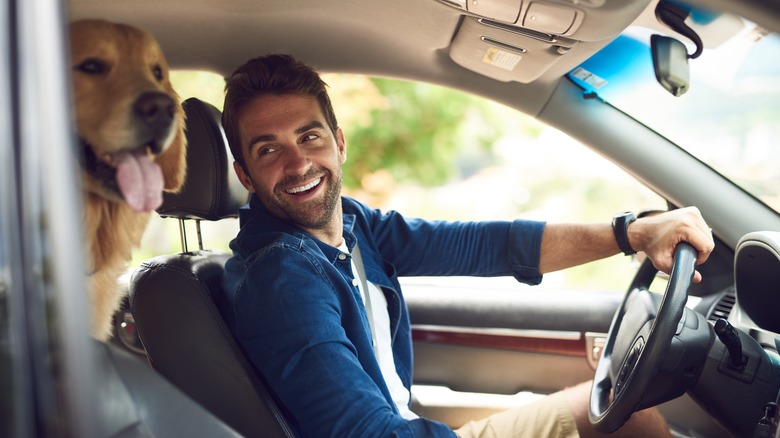 man with dog in car