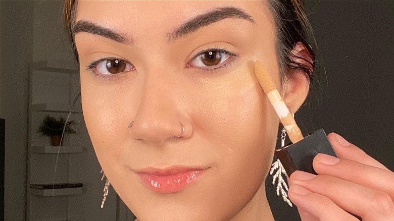 woman applying concealer 