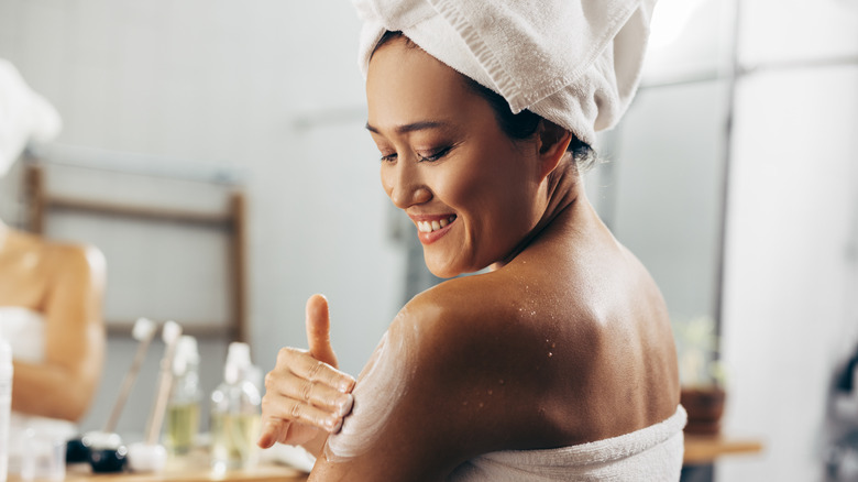 woman applying cocoa butter lotion