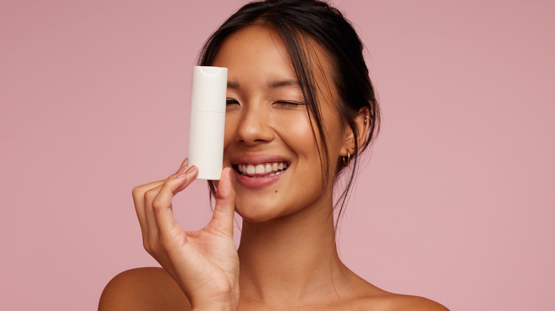 Woman holding up skin care bottle