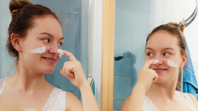 A woman applying skincare 