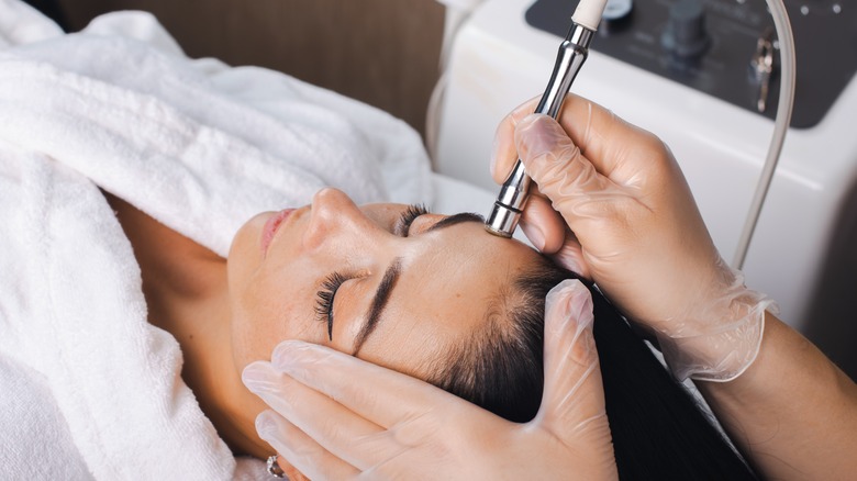 Woman receiving facial beauty treatment