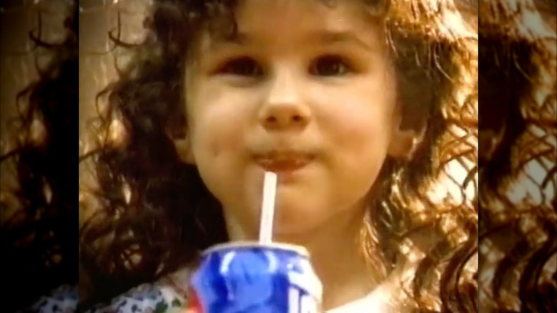Hallie Eisenberg smiles while drinking soda in a Pepsi commercial