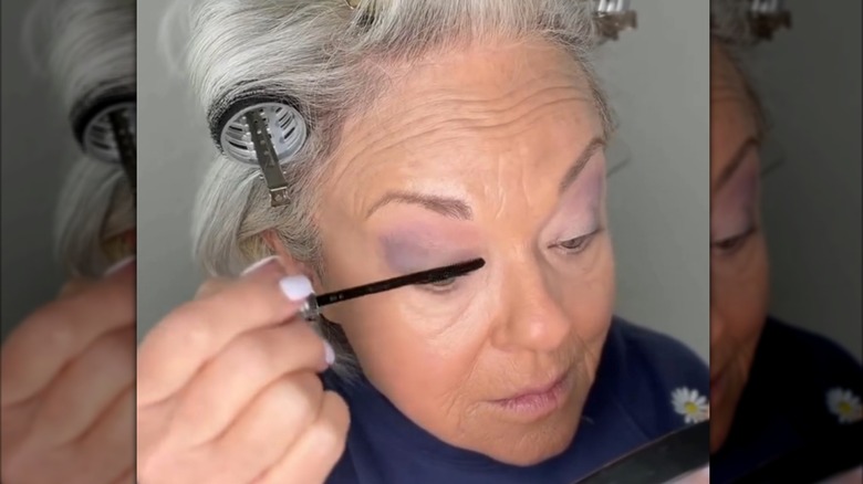 Mature woman applying mascara