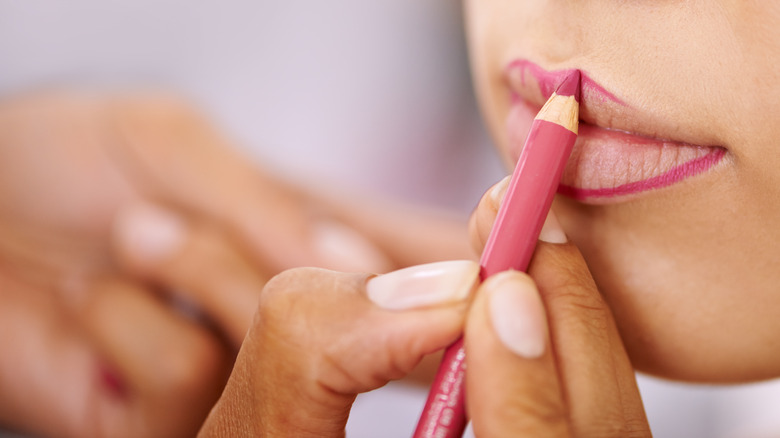 person lining woman's lips