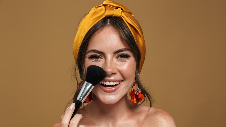 woman using large makeup brush