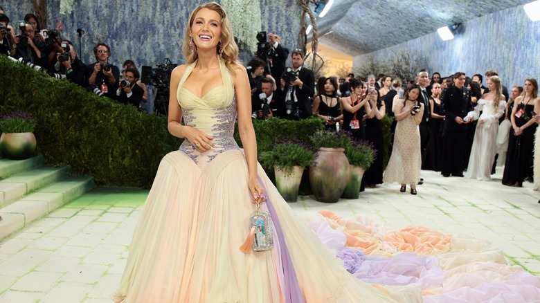 Blake Lively posing at the 2026 Met Gala in a pastel-colored dress with a long train.