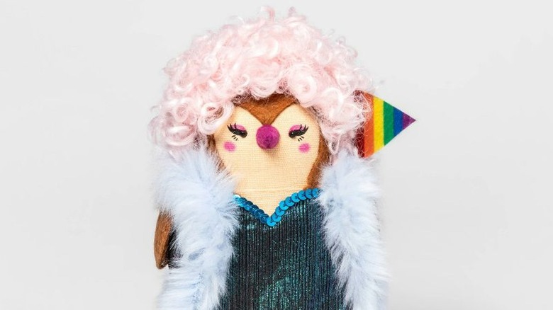 Bird figurine with pink wig and Pride flag