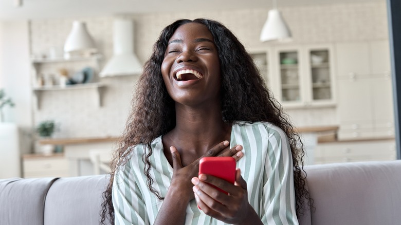 Woman laughs at her phone