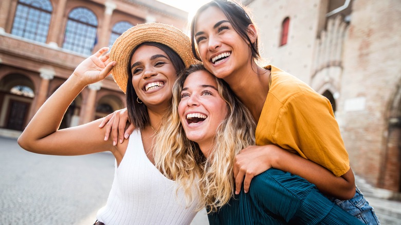 Three women smiling and hugging