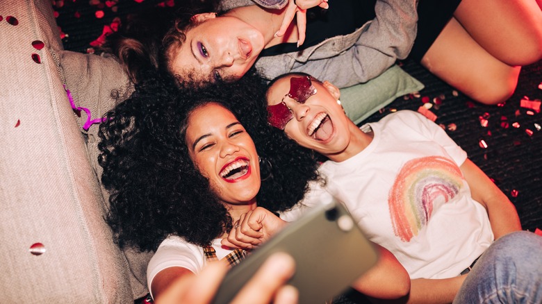 Friends laying on floor taking selfie