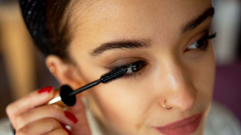 woman applying black mascara