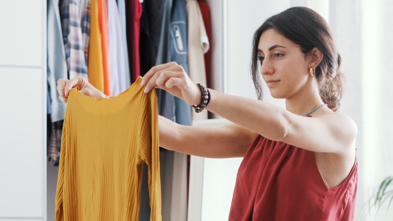 Woman looking at long sleeve shirt