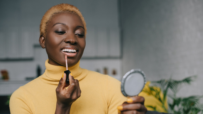 Woman applying lip gloss 