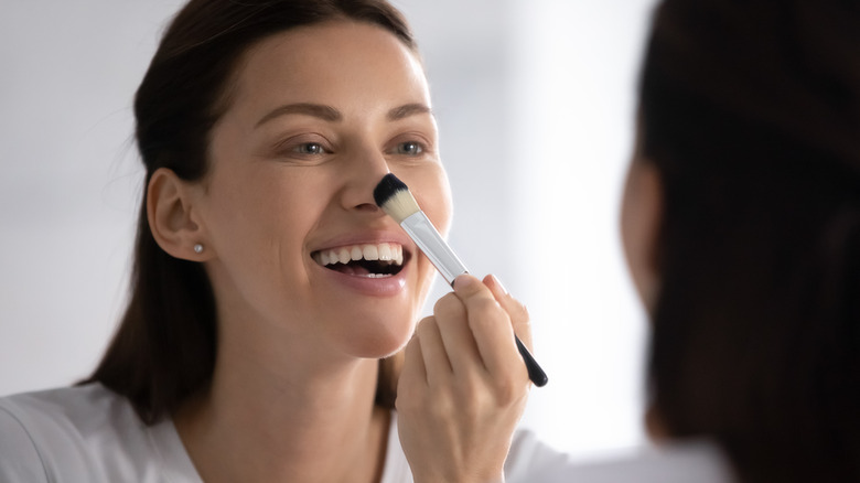 person doing makeup in mirror