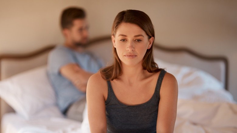 Couple in bed looking unhappy 