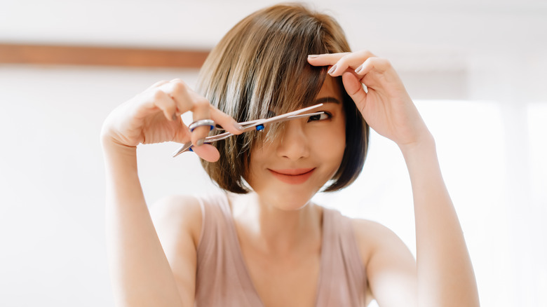 Woman cutting her hair 