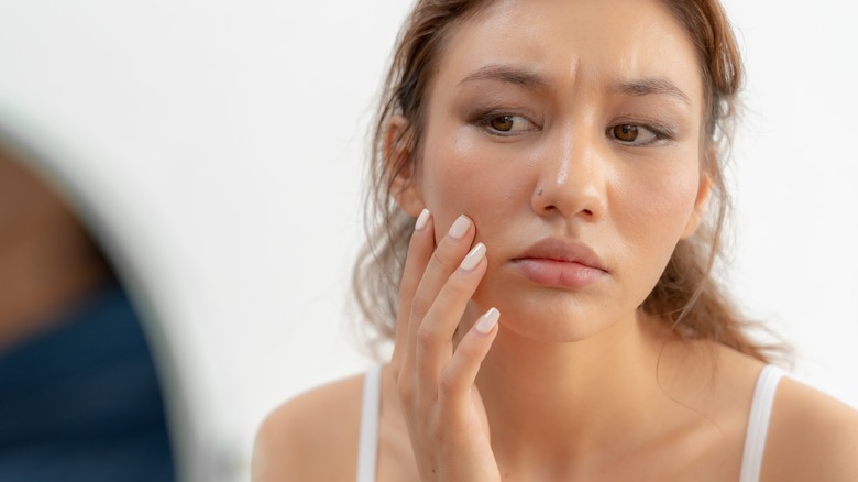 Woman looking at pores on face 