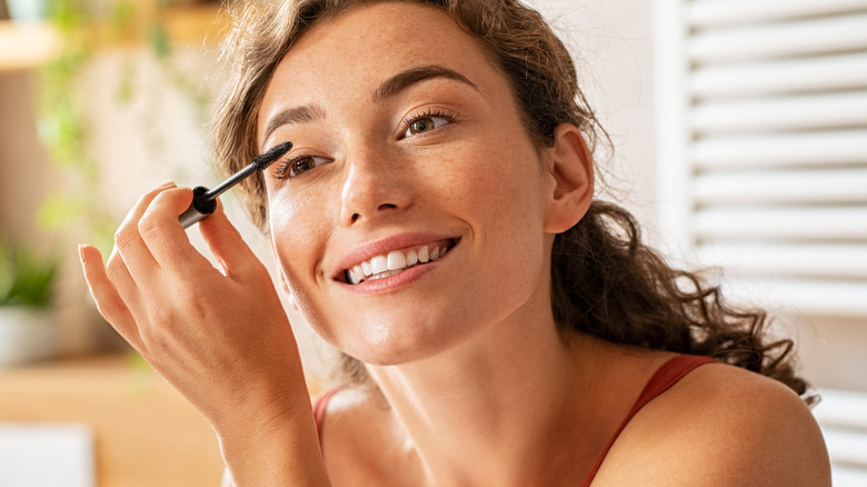 Woman applies mascara