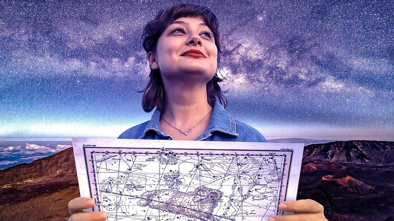 Woman using star map for astrocartography