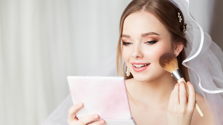 Bride putting on makeup 