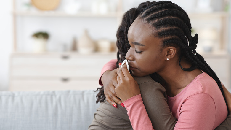 Two women embrace