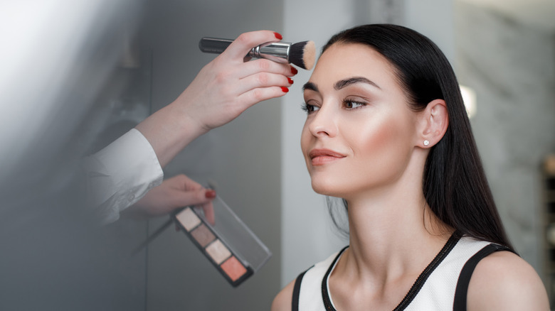 woman getting her makeup done