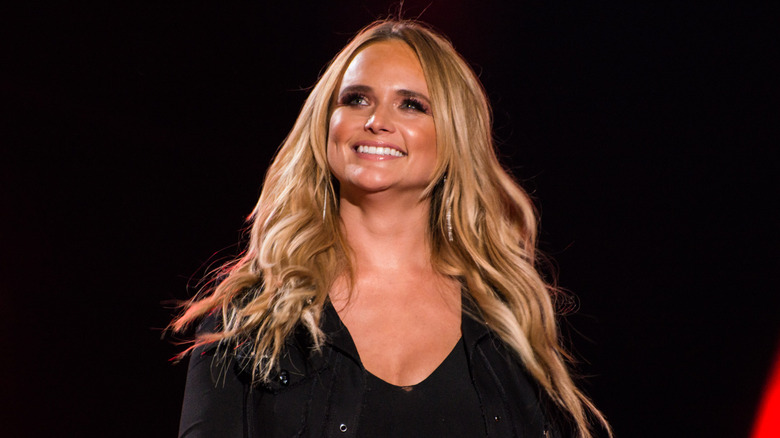 Miranda Lambert smiles and looks at the crowd while performing on stage
