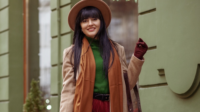 Model wearing outfit including brown leather gloves