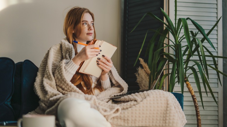woman journaling on sofa