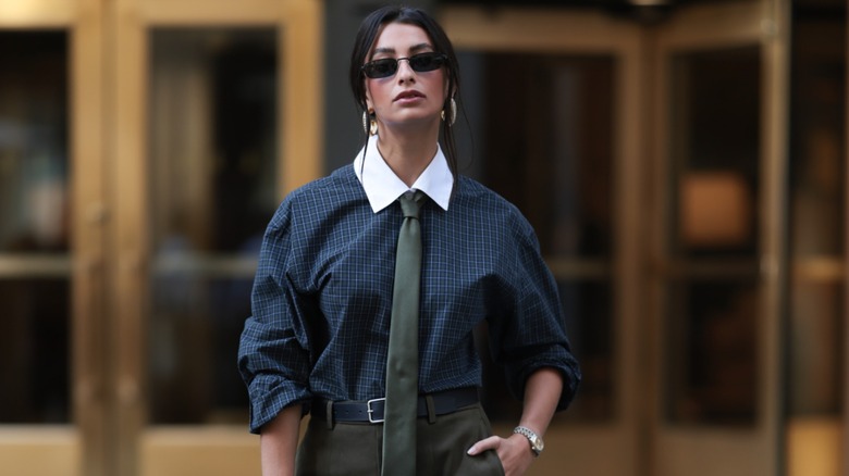 Marisa Lauren wearing a preppy button-up shirt and tie with olive green culottes and brown suede boots