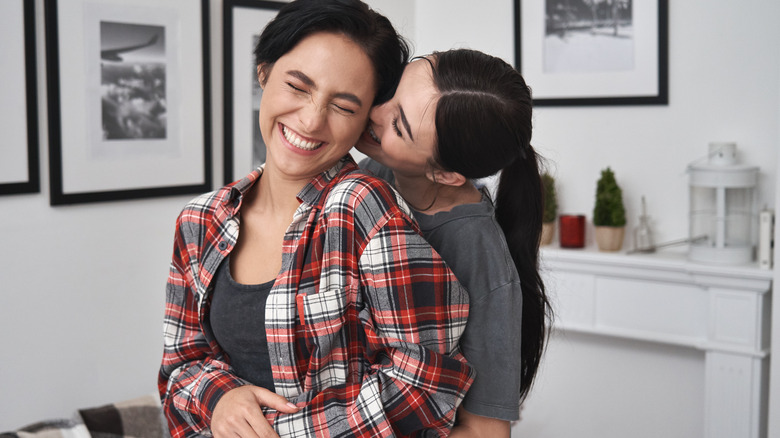 Woman kissing girlfriend from behind