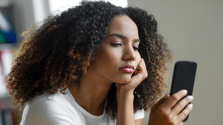 woman looking at phone concerned 