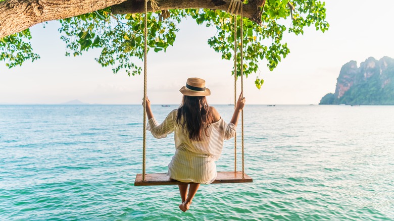 Woman swinging over a lake 