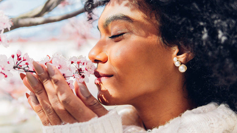 peaceful woman smelling cherry blossoms