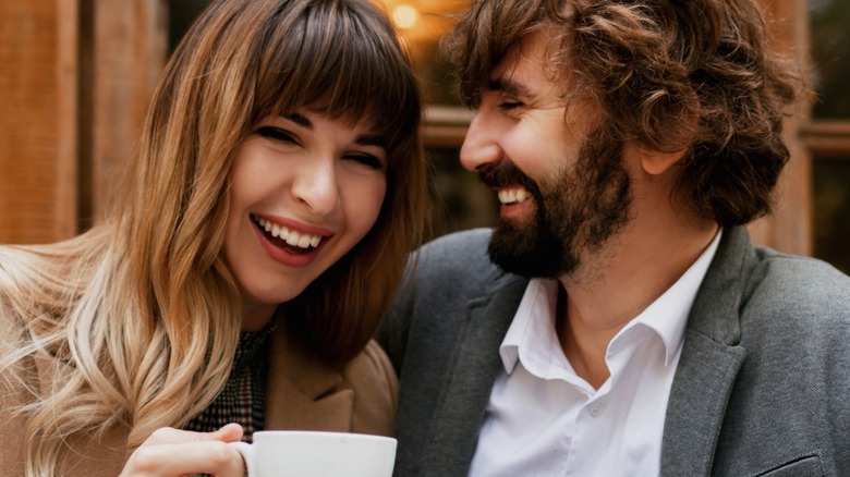 Couple smiling and drinking coffee