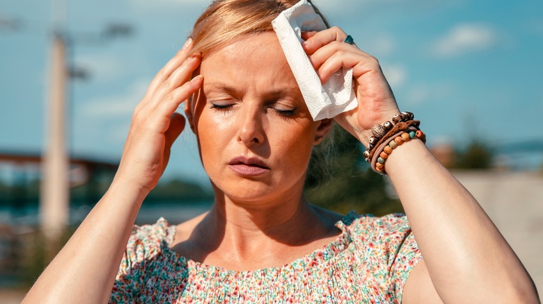 Woman wipes forehead