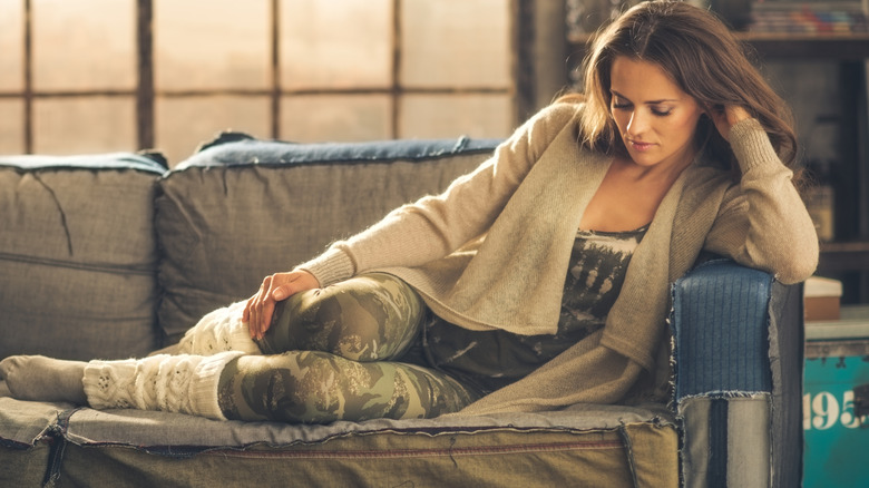 Woman wearing a long cardigan and camo leggings