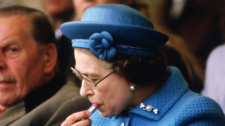 Late Queen Elizabeth II applying lipstick