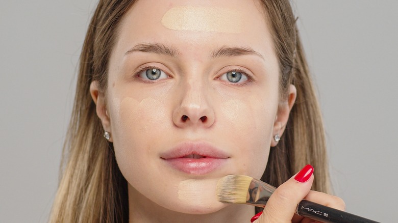 A woman applying foundation